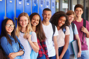 group of diverse teens standing in front of blue lockers